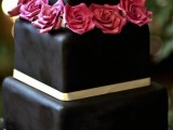 a sleek black square wedding cake with neutral ribbon and pink roses is a stylish and classic idea to rock, it’s always a good idea