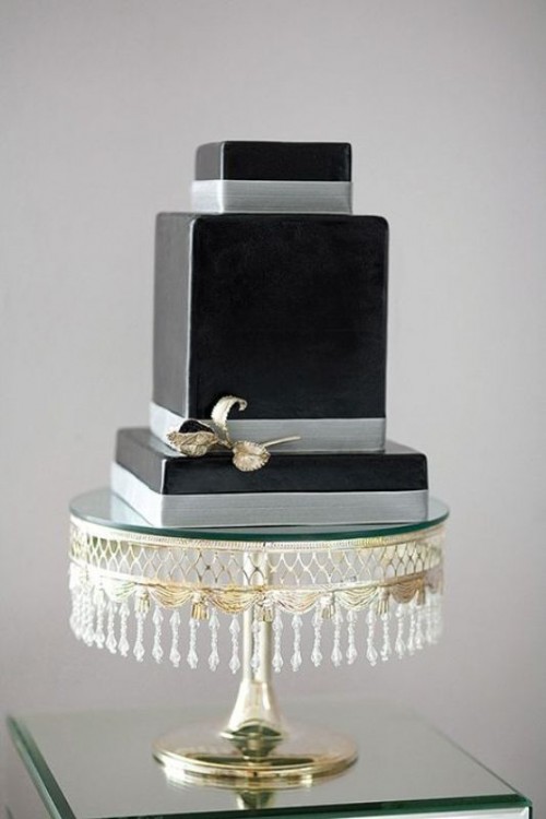 a minimalist sleek black square wedding cake with silver ribbon and no other decor is a stylish and cool idea to rock