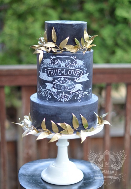 a black chalkboard wedding cake with chalk patterns and letters, with gold leaves is a cool idea for a casual wedding