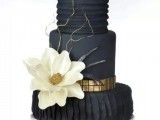 an elegant and refined black wedding cake with textural and plain tiers, gold ribbon and white sugar blooms plus twigs is a gorgeous idea for a refined wedding