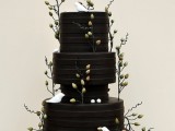 a striped black wedding cake with twigs with berries and white birds, all made of sugar are cool for a modern wedding