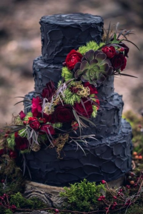 a textural black wedding cake with burgundy and red blooms, greenery, feathers and succulents is a unique idea to try