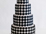 a white wedding cake with black polka dots and a white sugar bow on top is a bold and contrasting idea for a modern wedding