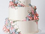 a white wedding cake with pastel blooms and greenery of sugar is a chic vintage wedding idea