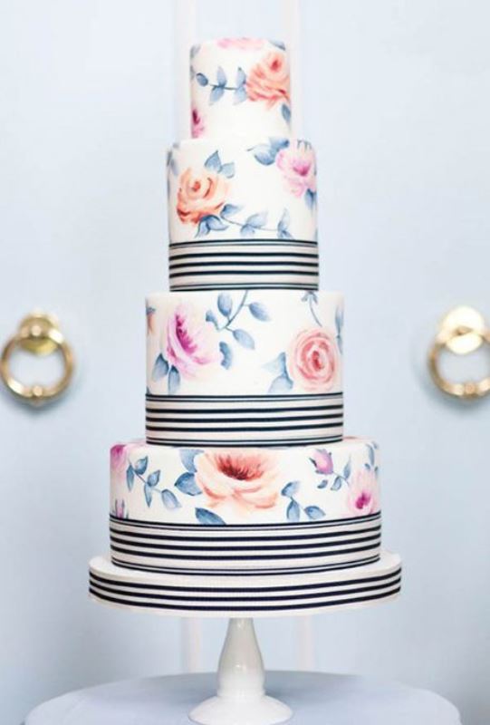 A pastel floral wedding cake with black and white stripes is a stylish idea inspired by vintage