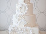 a white wedding cake with lace, beads and ruffles looks refined, chic and stylish