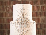a textural white wedding cake decorated with matte and shiny beads looks really chic and beautiful