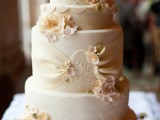 a neutral wedding cake with textural tiers and sugar blooms, monograms and sugar ribbons plus sugar greenery