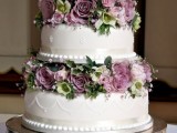 a white wedding cake with white decor, silk ribbons, fresh mauve blooms and greenery is very chic