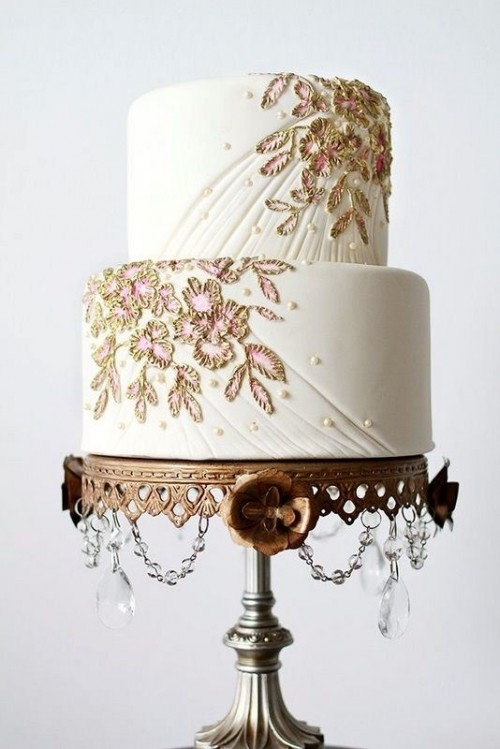 a white textural wedding cake with beading and gold and pink floral detailing is a sophisticated idea