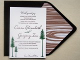a black envelope with wood grain lining and an invitation with tree prints is a cool idea for a winter wedding
