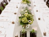 a neutral wedding tablescape with white floral arrangements and greenery, potted succulents, wood pieces to hold the cards – these card holders give a woodland or rustic feel to the table