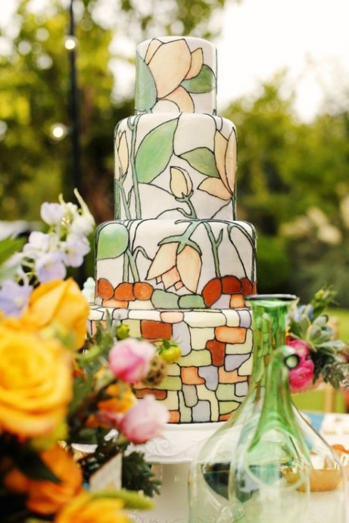 a white buttercream wedding cake painted with blooms, greenery and colorful dots is a lovely idea for a spring or summer wedding