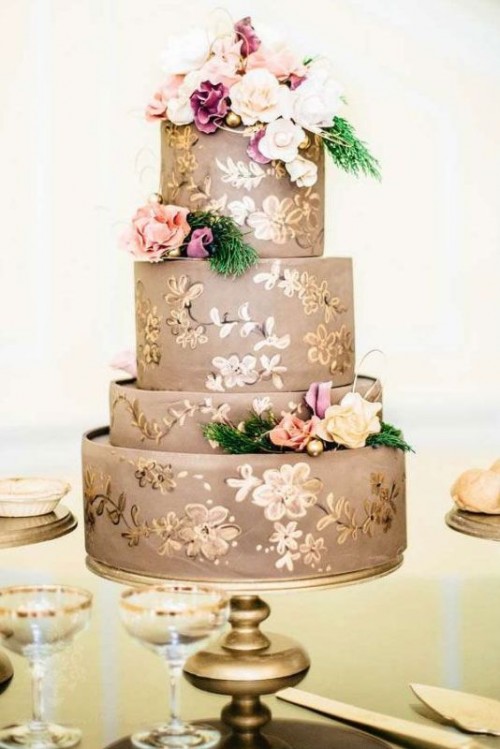 a taupe wedding cake painted with gold flowers and topped with pastel and neutral blooms and greenery is a refined and elegant idea for a wedding