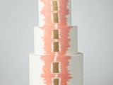 a white buttercream wedding cake with coral and gold hand painting is a cool and bold idea for a modern wedding with plenty of color