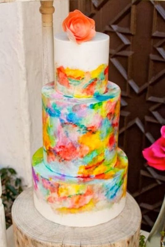 a white buttercream wedding cake with super bold and colorful watercolors for a bright and colorful wedding in spring or summer