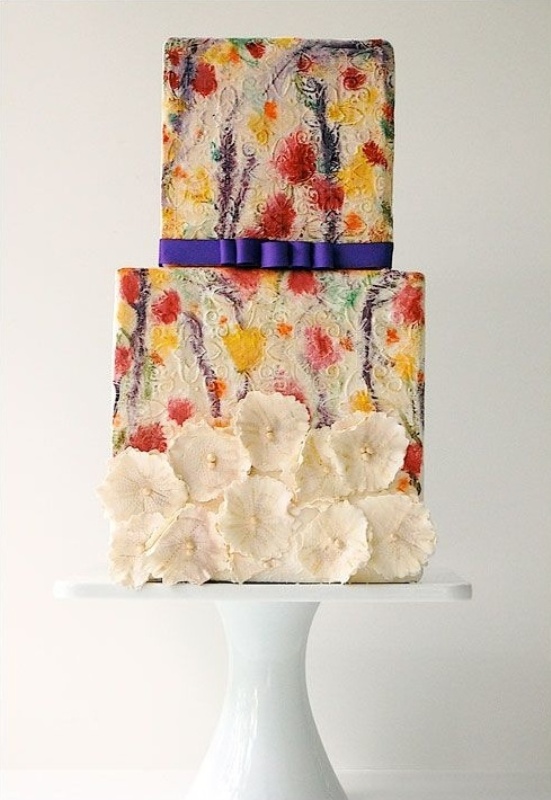 a unique square colorful and textural wedding cake with painted blooms, a navy ribbon and white sugar blooms attached is an amazing idea for a summer wedding with bright shades