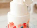 a white buttercream wedding cake with a colorful watercolor flower tier and a white sugar bloom is an amazing idea for a colorful spring or summer wedding