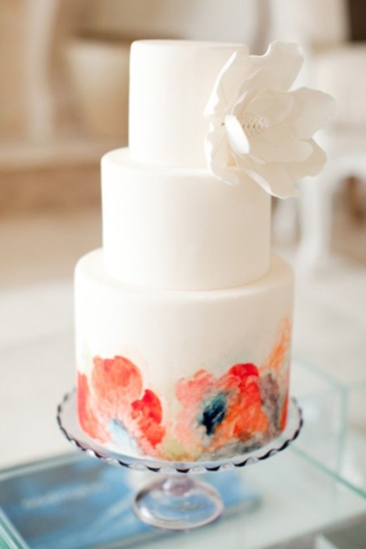 a white buttercream wedding cake with a colorful watercolor flower tier and a white sugar bloom is an amazing idea for a colorful spring or summer wedding