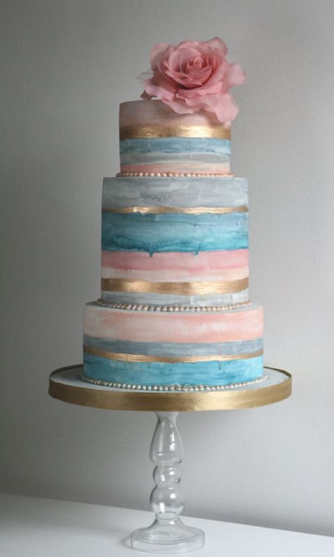 a beautiful blue and pink handpainted wedding cake with gold touches and a large pink bloom on top is a gorgeous idea for a spring or summer wedding