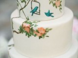 a white buttercream wedding cake with handpainted blooms and birds is a lovely idea for a spring or summer wedding, it looks very pretty and whimsy