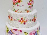 a white wedding cake decorated with bright handpainted blooms and leaves, with painted little bird cake toppers is an amazing idea for a bright wedding