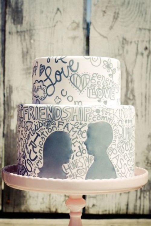 a white buttercream wedding cake with hand painted black letters and silhouettes is a cool idea to say what you want