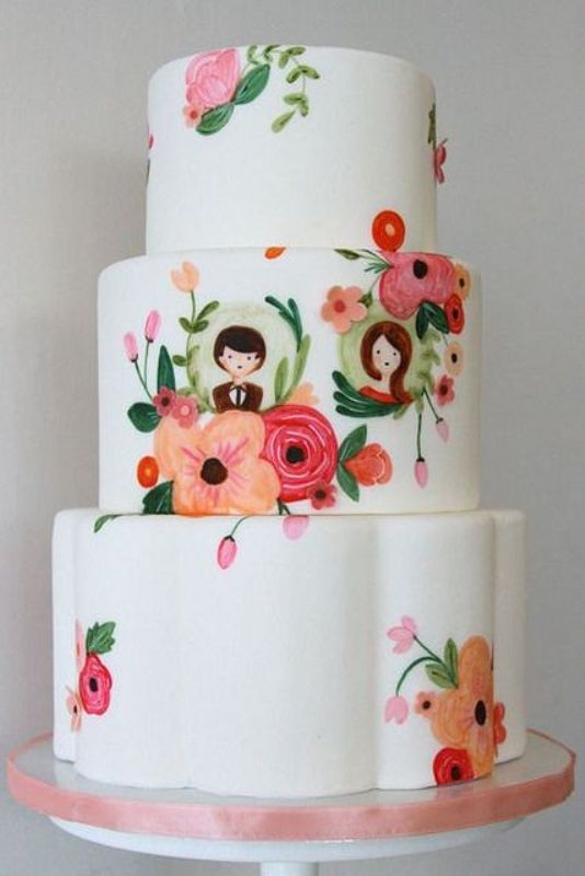 a white buttercream wedding cake with bold painted blooms, little portraits of the couple is a lovely idea for a summer wedding