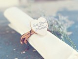 a vine napkin ring with a plywood heart with wood burning is a pretty and cool idea for a rustic or just relaxed wedding
