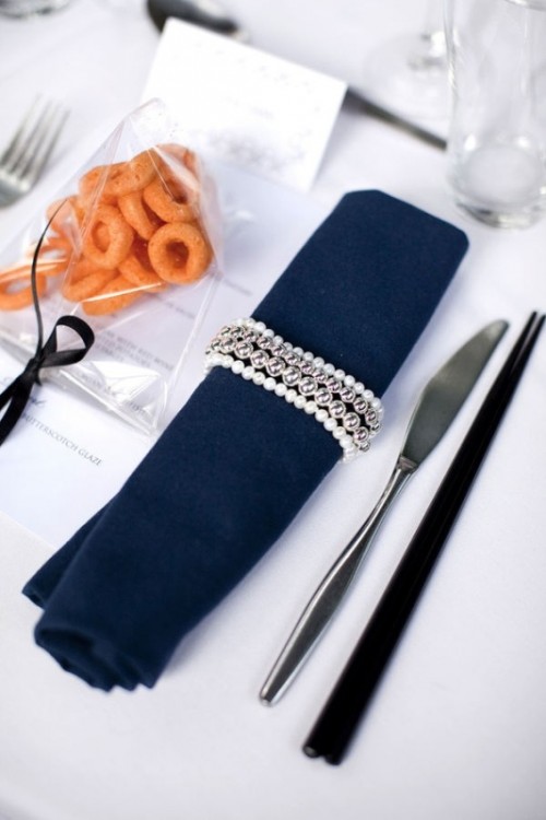 a glam pearl and bead napkin ring beautifully accents a navy napkin and it will add glam to your tablescape