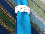 a white rope napkin ring is a perfect match for a coastal or nautical wedding tablescape