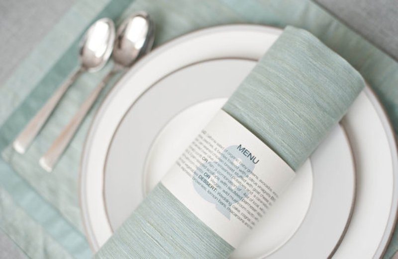 a mini menu styled as a napkin ring is a very creative, fresh and modern that allows you to save some money