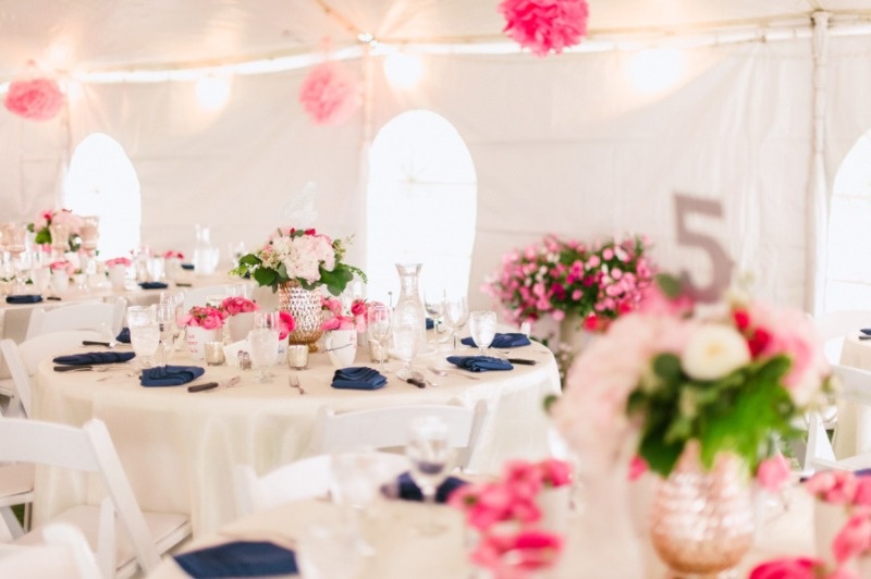 a spring wedding reception done in neutrals and spruced up with pink and navy touches, bright blooms and greenery