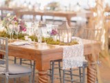 a cozy and casual spring wedding reception with lace table runners, moss, bright flowers and candle lanterns