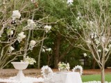 neutral and blooming spring reception space done with whte blooms on branches, blooms on the ground and blooms on the chairs