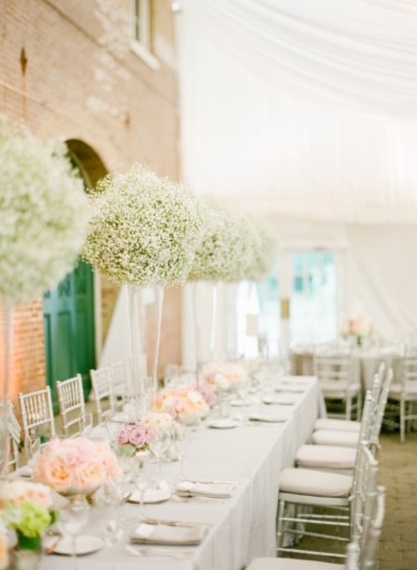 a romantic indoor spring wedding reception with tall baby's breath centerpieces, pastel blooms and white linens