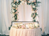 blush and white blooms, candles in candleholders and a lush floral arch of neutral blooms and greenery