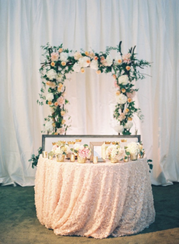 blush and white blooms, candles in candleholders and a lush floral arch of neutral blooms and greenery