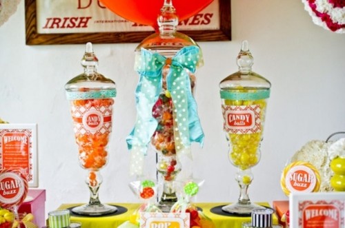 a colorful candy bar in jars with colorful bows and ribbons is ideal for a retro wedding