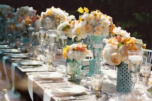 an aqua blue, white and yellow wedding tablescape with lush florals for a retro wedding