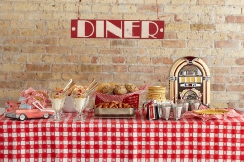 a cool cookies, pancakes and sweets station done in red and white, with a plaid tablecloth, a toy retro car