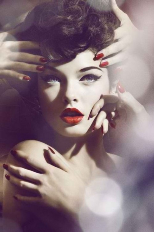 a retro-inspired makeup with cat eyes eyeliner, deep red lips and wavy updo for a retro bride