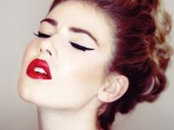 a retro-inspired makeup with cat eyes and a bold red lip and a wavy updo