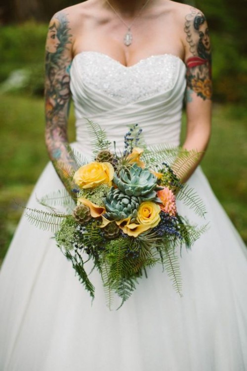 a draped strapless embellished wedding ballgown that shows off bold bride's tattoos on the shoulders and arms