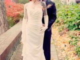a draped strapless wedding dress shows off bride’s tattoos on the shoulders and arms and long gloves accent them