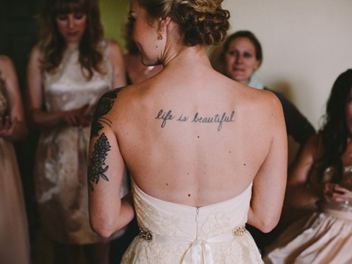 a strapless and backless wedding dress show off the bride's back tattoo at its best