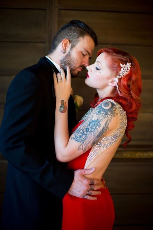 a gorgeous red embellished wedding dress with a cutout back and no sleeves shows off beautiful bride's tattoos on the arm, wrist and shoulder