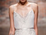 a delicate lace and plain wedding dress with embellishments shows off the bride’s tattoos as there are no sleeves