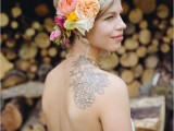 a strapless and backless wedding dress allows to see the bride’s tattoo on the back and shoulder