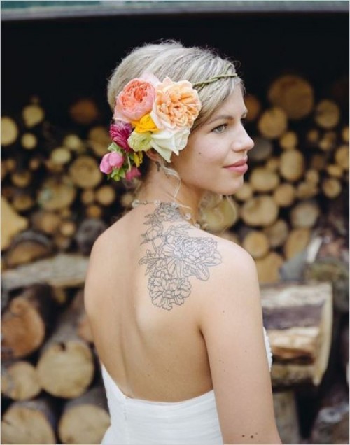 a strapless and backless wedding dress allows to see the bride's tattoo on the back and shoulder